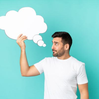 Young handsome caucasian man isolated on blue background holding a thinking speech bubble